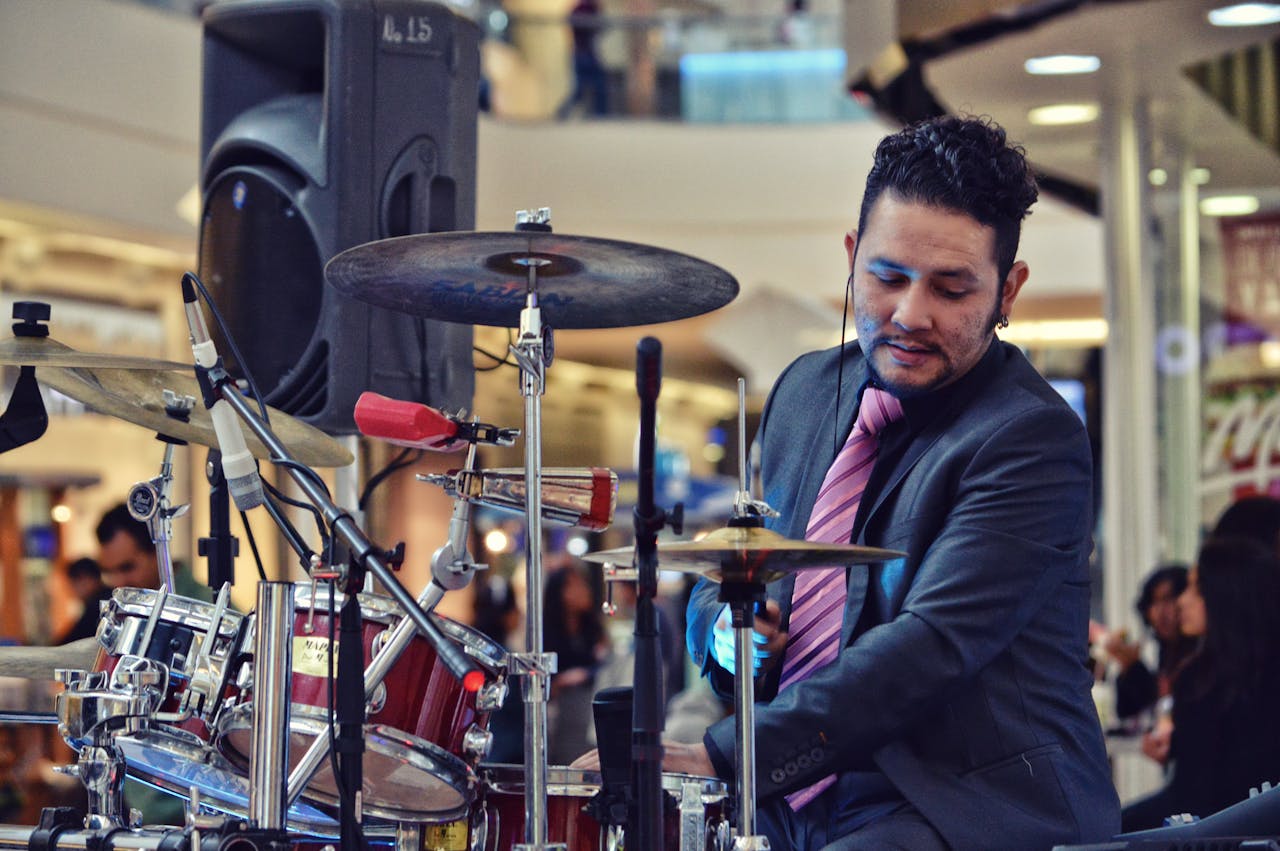 Musician playing drums indoors at a mall event, adding vibrant rhythm to the shopping atmosphere.